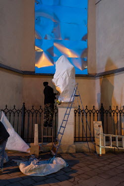 Church windows and statues being boarded up and wrapped to protect them against potential damage from the war in the old city centre, an UNESCO heritage site.