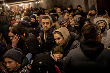 A mother and her son, who have been waiting more than 12 hours, stand in the middle of a large crowd gathered at the train station in Lviv, the main hub for people trying to escape the war in Ukraine....