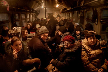 After a wait of many hours, people squeeze onto a carriage on a train which is heading to Poland. Huge numbers of people, mainly women and children, have gathered at the train station in Lviv, the mai...