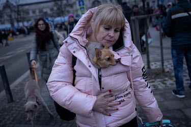 A woman fleeing her home arrives at the train station in Lviv carrying her pet dog inside the jacket to keep it warm. The station is the main hub for people trying to escape the war in Ukraine. Most o...