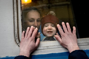 A father holds his hands up to the window of a departing train to say farewell to his wife and child who are fleeing to safety in Poland.  Under martial law, men aged 18 to 60 are not allowed to leave...