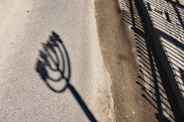 The shadow of a Menorah forming part of a gate at the tomb of Rabbi Nachman that has become a sacred shrine attracting tens of thousands of Jewish pilgrims from all over the world.