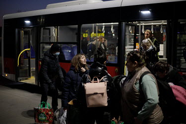 Ukrainian refugees gather outside an old Tesco supermarket building, which has been converted into a humanitarian aid centre. It is here that people will board the coaches that will transport them to...