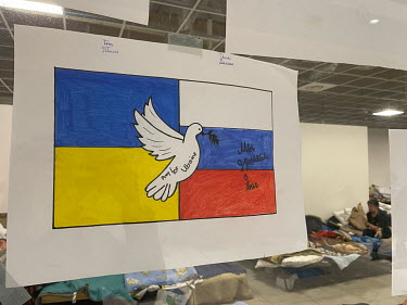 A drawing for peace featuring a dove and Ukrainian and Russian flags. Russian writing on the right says 'We are thinking about you'. It has been sent to Ukrainian refugees at an old Tesco supermarket...