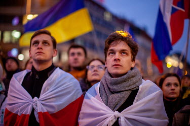 Two men wrapped in the flag of previous Belarus flag, which became the symbol of resistance to President Lukashenko, stand among the thousands of people gathered in Prague's Wenceslas Square to protes...