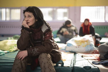 Ilena Pavlenko, sits on a mattress in the gym of school 102, in the Shuliavska district.  Her apartment building was randomly shelled in the night. Her flat, on the fourth floor, which is home to her...