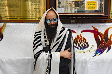 A Hasidic man prays in a synagogue.