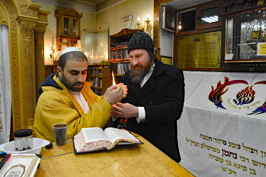 Hasidic men pray and study in a synagogue.