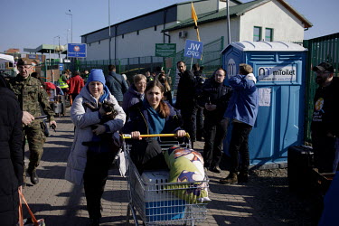 Ukrainian refugees, including a woman with a cat, enter Poland after passing the immigration post and crossing into Poland.