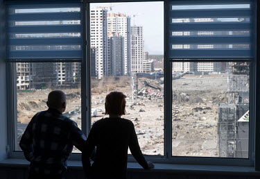Mikhail and Nataliya Moskalenko look out of a broken window at the bombed Retroville Mall. They spent the night of the shelling in the buiding's basement.