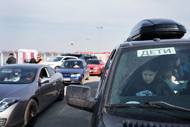 A car displays a sign saying 'children'. Many people have stuck this sign or a white flag in the car before traveling out of Ukraine to show they are leaving and to avoid attack.