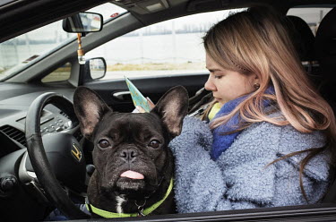 A young Ukranian refugee traveling with her dog fills in a form in her car before going through border control.