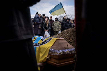 Oksana Ruschyshyn and her three children watch as their husband and father is buried three days after he was killed on 7 March 2022 during a battle with invading Russian forces in the Luhansk region....