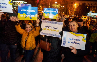 People gather together in front of the Donetsk Regional Drama Theatre in Mariupol holding placards declaring that 'Mariupol is Ukraine'.