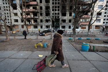 A woman passes a badly damaged residential apartment block, in one of several civilian, residential areas of western Kiev that were targeted by Russian shelling over several days in the third week of...