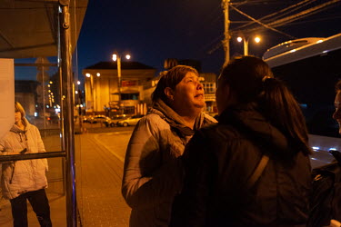 A woman cries after a group of evacuees from Chernigiv arrive by mini bus at the Central Railway station.