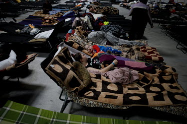 Ukrainians, displaced by the war, sleep on camp beds at the humanitarian help centre established at the giant Ptak Expo buildings on the outskirts of Warsaw.