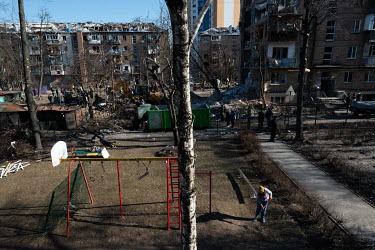 A woman clears the children's playground area in a residential housing estate, one of several civilian, residential areas of western Kiev that were targeted by Russian shelling over several days in th...