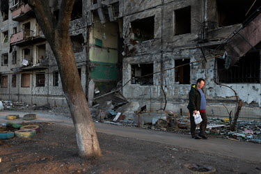 A man passes a badly damaged residential apartment block, in one of several civilian, residential areas of western Kiev that were targeted by Russian shelling over several days in the third week of Ru...