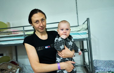 Tolya holding her eight month old son in the Door to Heaven (Dveri v Nebo) Christian Church where they found shelter after arriving that day from Berdyansk.Â� She decribed thier journey: "It took us...