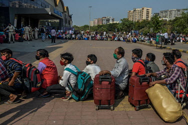 Migrant workers queue outside the Lokmanya Tilak Terminus (LTT) station to get to a train departing to their home towns after it became clear that the local government was considering a complete lockd...