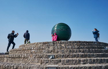 A man photographing his children in front of the Globe of Wishes (Kulia bazhan) on Sicheslavska Naberezhna Street. People, mostly internally displaced persons (IDPs), enjoy the nice weather despite th...