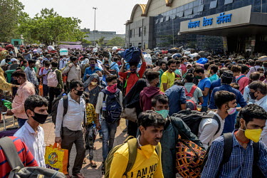 Migrant workers rush outside the Lokmanya Tilak Terminus (LTT) station to get to a train departing to their home towns after it became clear that the local government was considering a complete lockdo...