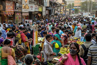 People flout COVID-19 norms of social distancing in order to shop in a local market in Dharavi as the number of COVID-19 cases surge in the city.
