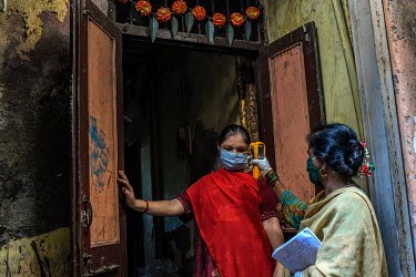 Health workers take oxygen readings and body temperatures of residents while carrying out contact tracing in the slums of Dharavi.