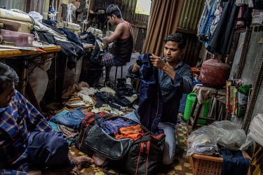 Karim Ansari (right) who works in a local footwear factory packs his bag at his friend's shop as he planning to leave that night by train from Mumbai to his hometown. The factory owner where he works...