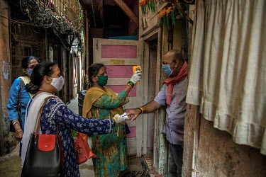 Health workers take oxygen readings and body temperatures of residents while carrying out contact tracing in the slums of Dharavi.