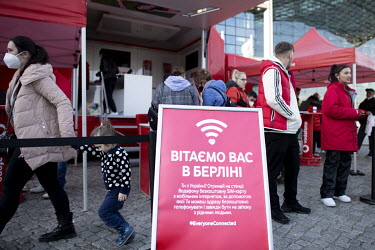 Ukrainian refugees receive free sim cards from a Vodafone stall at an arrivals centre in the Hauptbahnhof, the train station where Ukrainian refugees disembark trains From Poland.