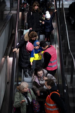 A volunteer offers comfort to a child, wearing a jacket in the Ukrainian colours, after he and his mother disembarked a train from Poland that has just arrived at the Hauptbahnhof, Berlin's main railw...