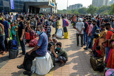 Migrant workers queue outside the Lokmanya Tilak Terminus (LTT) station to get to a train departing to their home towns after it was announced that the local government was implementing a complete loc...