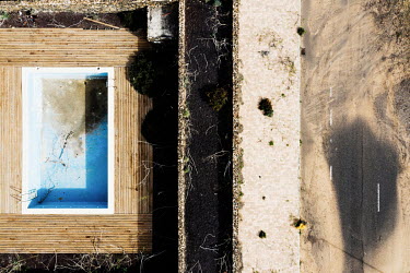 An empty and decrepit swimming pool seen from above at Residencial Origo Mare, in La Oliva, Fuerteventura.