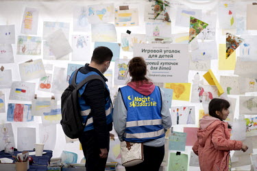 'Night Solidarity' volunteers look at children's drawings at the arrivals centre at the Hauptbahnhof, the railway station where Ukrainian refugees disembark trains from Poland.
