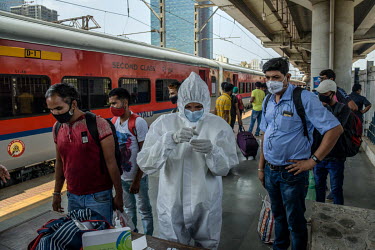 A health worker carries out lateral flow antigen COVID-19 rapid tests on passengers arriving from outside of the city at Dadar railway station.