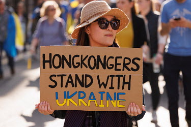 A woman holds a placard that reads: 'HONGKONGERS STAND WITH UKRAINE' during a protest against the Russian invasion of Ukraine in central London.
