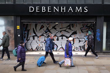 People walk past a closed-down branch of Debenhams department store after the firm went into administration. The high street staple, which has been in financial difficulty for some time, is being take...