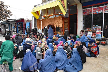 Women and children begging outside a bakery.