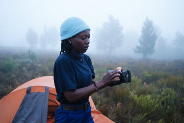 Zikhona Gcakamani, leader of a high-angle tree clearing team, polishing her work boots at dawn at her team's campsite in a remote montane catchment area that feeds the Theewaterskloof dam. The teams a...