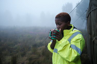 Zanele Njilana, a member of a high-angle tree clearing team, enjoying an early morning cup of coffee before the start of the day at her team's campsite in a remote montane catchment area that feeds th...