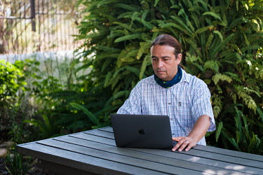 Prof. Tulio de Oliveira at a table in the garden surrounding the building where his office is located that he jokingly refers to as one of his 'meeting rooms' at the University of Stellenbosch. De Oli...