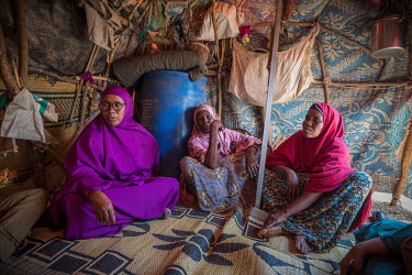 Local volunteer, Ibado (purple) talks with women in their shelter while on her daily rounds visiting IDPs displaced by drought in a camp near Oog.