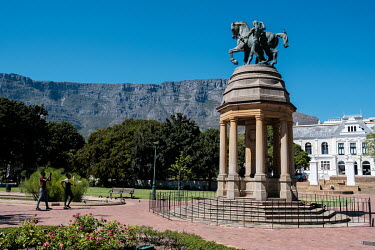 People looking at the Delville Wood Memorial in the Company's Garden with the iconic Table Mountain in the background. According to environmental NGO The Nature Conservancy, invasive non-indigenous tr...