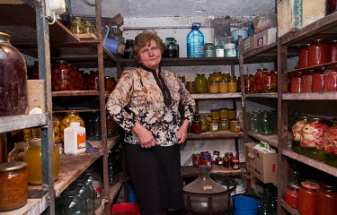 Tetiana Vitruk stands in a storeroom filled with preserved food at her home in a village on the western edge of Dnipro. She says she will not leave if Russian forces come to her village. She has enoug...