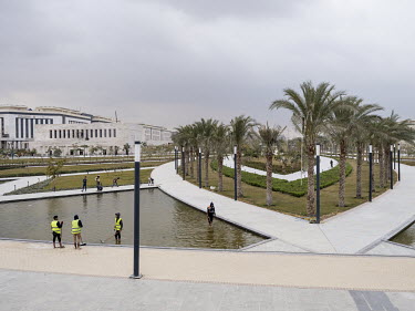 Workers clean water features in a garden in the Government District in Egypt's New Administrative Capital. Following persistent problems of overpopulation, pollution and traffic congestion, the constr...