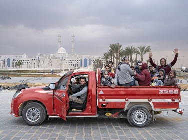 Workers on their way home pass the newly built Misr Mosque in Egypt's New Administrative Capital. The Misr Mosque will be one of the largest mosques in the world able to accomodate more than 100,000 w...