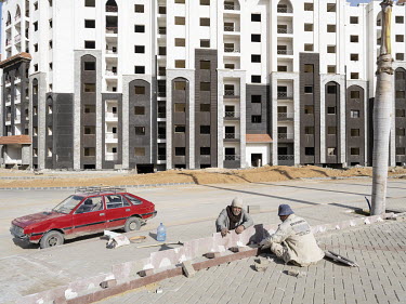 Workers placing tiles on a square in the Third Residential Neighbourhood (R3) in Egypt's New Administrative Capital. Following persistent problems of overpopulation, pollution and traffic congestion,...