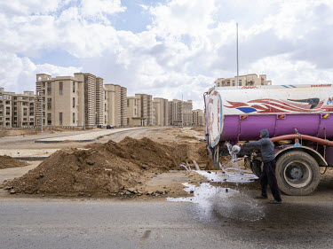 A worker rinces a bowl using water from a tanker in the First Residential Neighbourhood (R1) in Egypt's New Administrative Capital. Following persistent problems of overpopulation, pollution and traff...